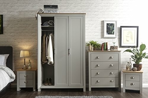 Modern bedroom with gray wardrobe and drawers, decorated with plants and framed art.
