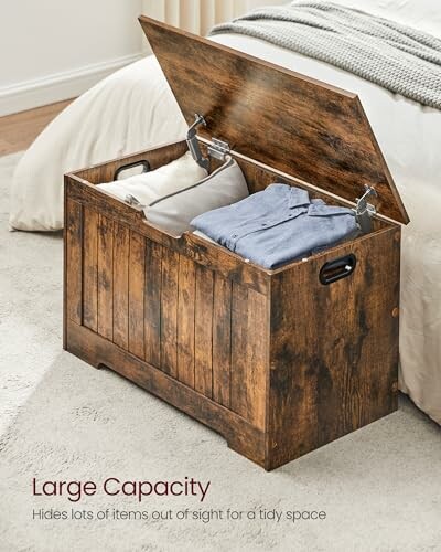 Open wooden storage chest with linens inside in a bedroom.